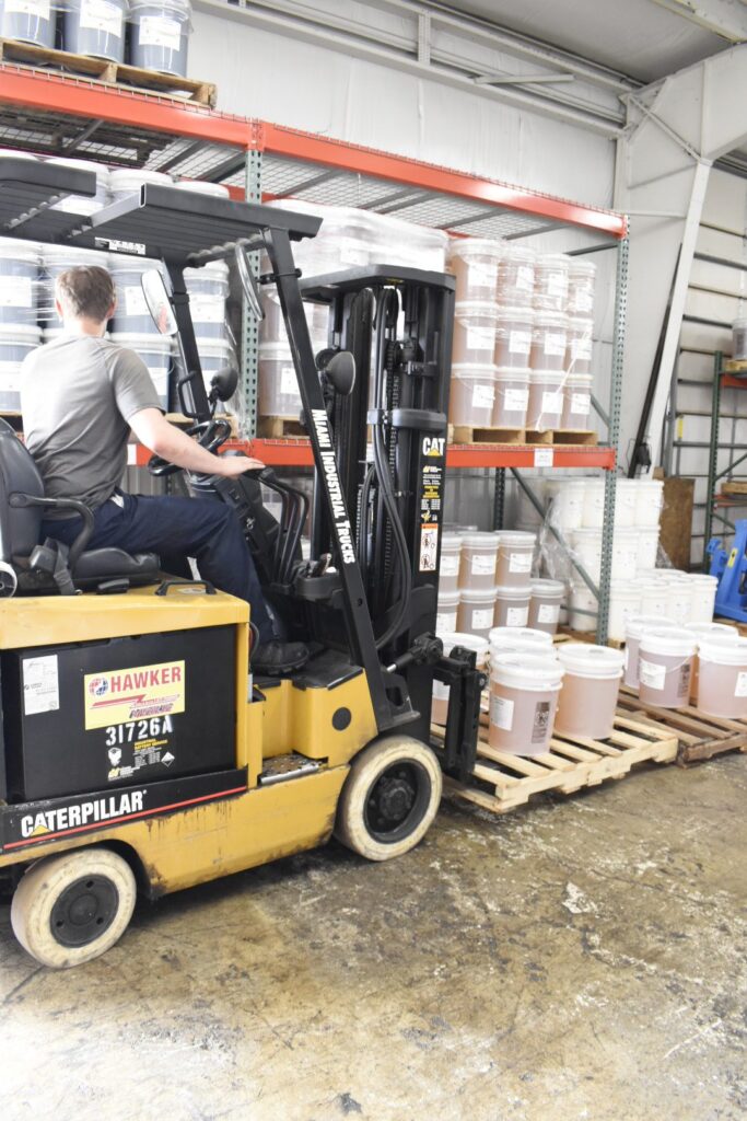 Loading Lubricant pails on skid for shipmentt